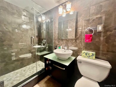 Bathroom with tile walls, a stall shower, and vanity