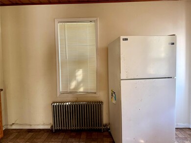 Kitchen with freestanding refrigerator and radiator heating unit