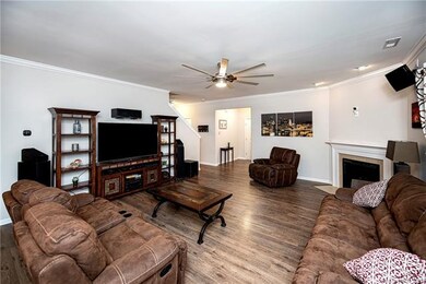 Great room with fireplace and 8 blade fan.