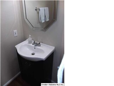 The half bathroom is located off a back hallway ne
