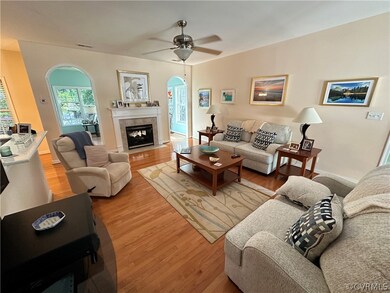 Living room featuring ceiling fan and hardwood / w