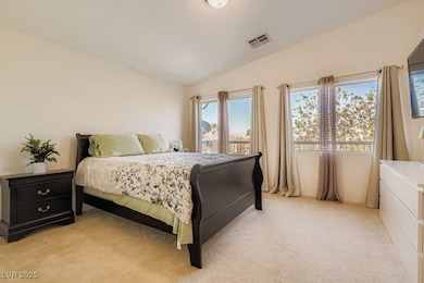 Bedroom featuring lofted ceiling and light colored carpet