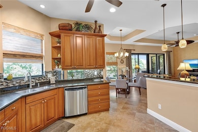 Kitchen with brown cabinets, tasteful backsplash, stainless steel dishwasher, dark stone counters, and recessed lighting