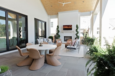 View of patio featuring outdoor dining space, ceiling fan, and an outdoor living space with a fireplace