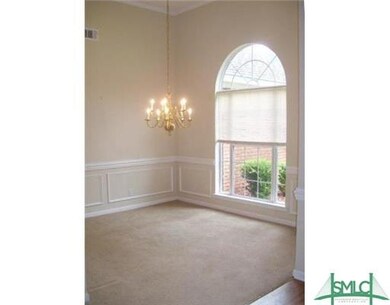 Formal dining room includes large window and beautiful gold chandelier.