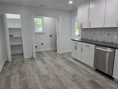 Kitchen with dishwasher, dark countertops, tastefu