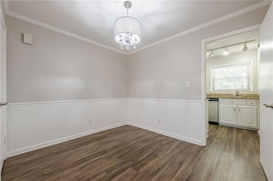 Spare room featuring a notable chandelier, wainsco