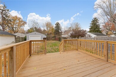 Wooden terrace with a fenced backyard, an outbuilding, a residential view, and a detached garage