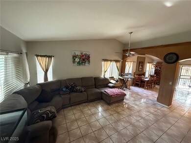 Living area with arched walkways, vaulted ceiling,