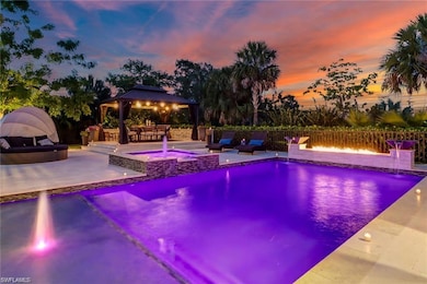 View of swimming pool with a gazebo, an in-ground hot tub, a patio area, a fire pit, and fence