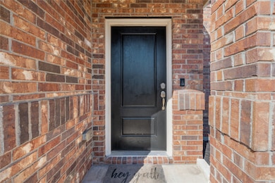 Property entrance featuring brick siding