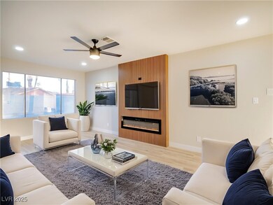 Living area with recessed lighting, wood finished floors, a glass covered fireplace, and a ceiling fan