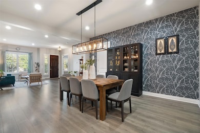 Dining area with wallpapered walls, an accent wal