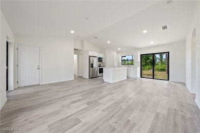 Unfurnished living room with vaulted ceiling, arch