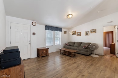 Living area with light wood-type flooring and lofted ceiling