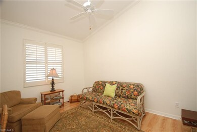 Den has vaulted ceiling and laminate wood look flo