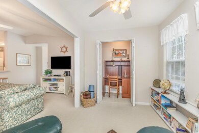 Living area featuring baseboards, a ceiling fan, a