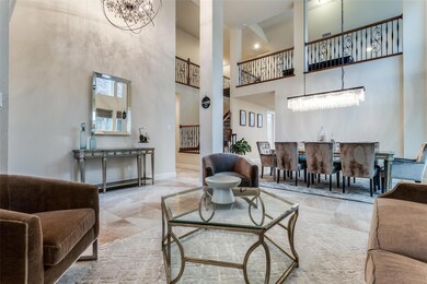 Tiled living room featuring a high ceiling and a chandelier