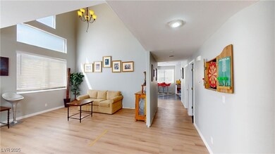 Hall featuring baseboards, a notable chandelier, a