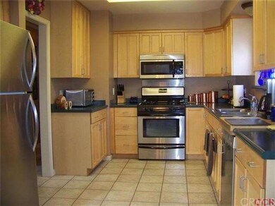 Kitchen with tiled flooring, plenty of cupboards a