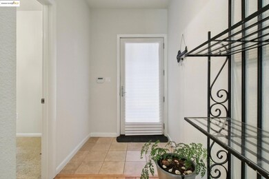 Doorway to outside featuring tile patterned floors and baseboards