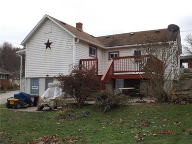 Rear view of home with access door to basement and