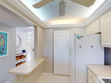 Kitchen with white cabinets, light tile patterned