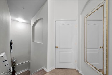 Hall featuring light tile patterned floors and bas