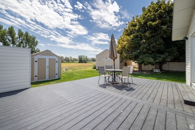 Wooden deck featuring a storage unit, a yard, and outdoor dining space