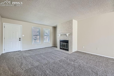 Unfurnished living room featuring a textured ceili