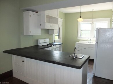Open kitchen with breakfast bar and wood flooring.