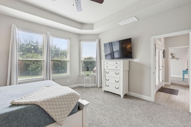 Carpeted bedroom featuring ceiling fan