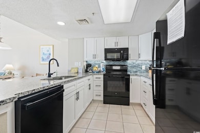 Kitchen with black appliances, white cabinets, light tile patterned flooring, decorative backsplash, and a textured ceiling