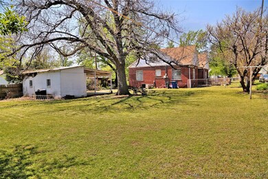 View of back yard from rear of the lot.  White bui