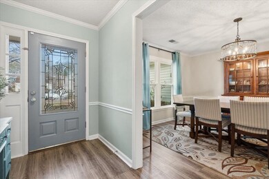 Foyer entrance with crown molding, a chandelier, a