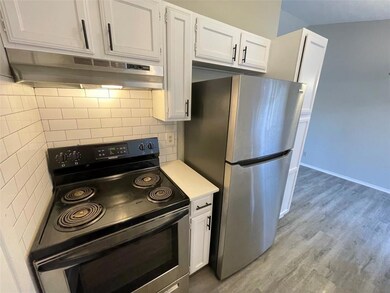 Kitchen featuring freestanding refrigerator, unde