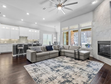 Living area featuring recessed lighting, a fireplace, a ceiling fan, and dark wood-style flooring