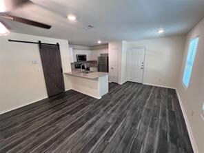 Kitchen featuring a peninsula, a barn door, light 