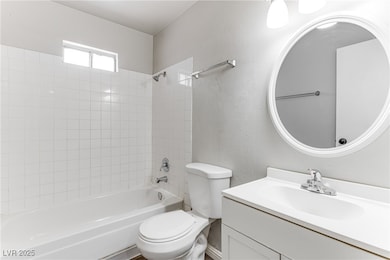 Full bathroom featuring washtub / shower combination, vanity, and a textured wall
