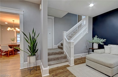 Staircase featuring a notable chandelier and wood-type flooring