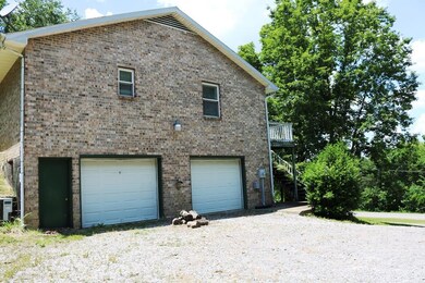 A side view of this solid brick home showing the garage entrance and two bays to the oversized garage.