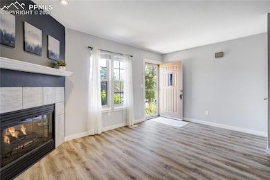 Unfurnished living room with a tiled fireplace, wo