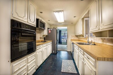 Kitchen with a textured ceiling, backsplash, butch
