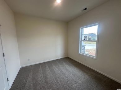 Spare room with visible vents, baseboards, and dar