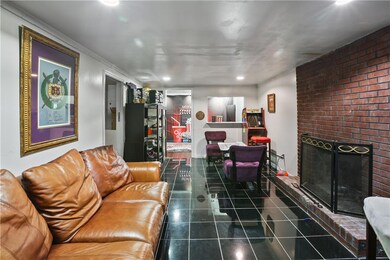 Living area with a fireplace, dark tile patterned floors, and recessed lighting