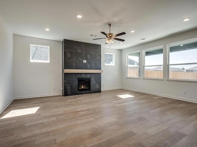 Unfurnished living room with wood finished floors, baseboards, ceiling fan, recessed lighting, and a fireplace
