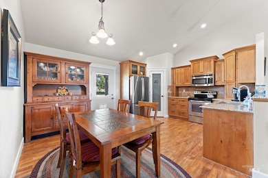 Dining space with lofted ceiling, a chandelier, light wood-type flooring, and recessed lighting