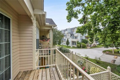 The balcony overlooks the lush tree-lined street.