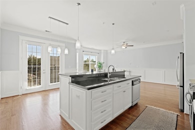 Crisp white cabinetry, central island with a sink,