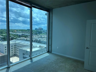2nd bed room featuring a view of city, plenty of natural light, expansive windows, baseboards, and carpet floors